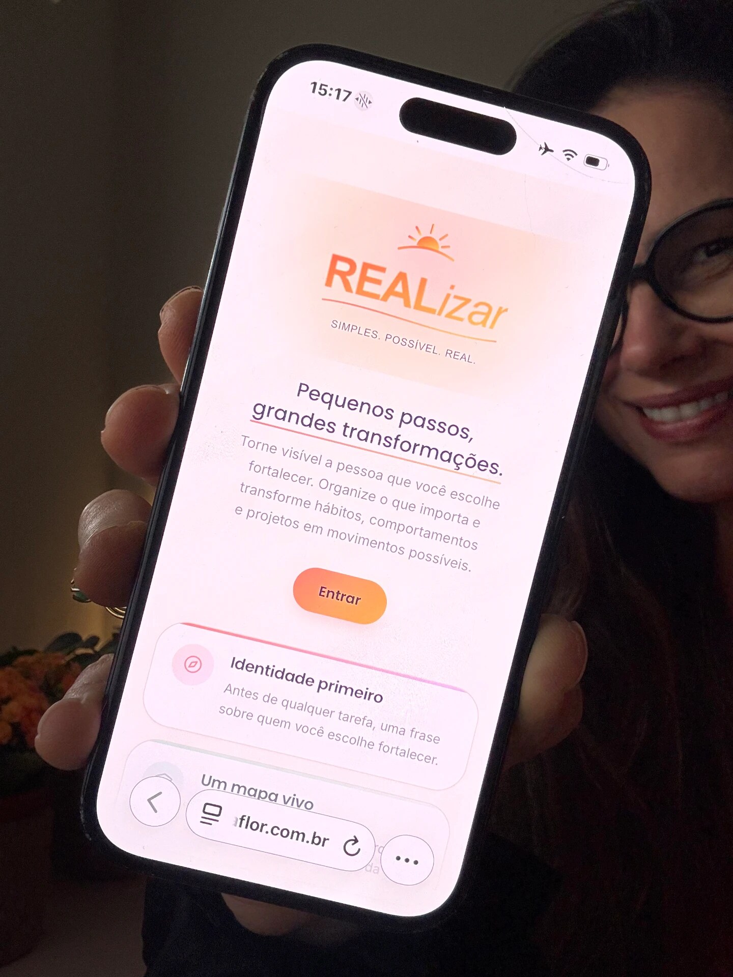 Pessoa segurando o celular com o aplicativo REALizar aberto